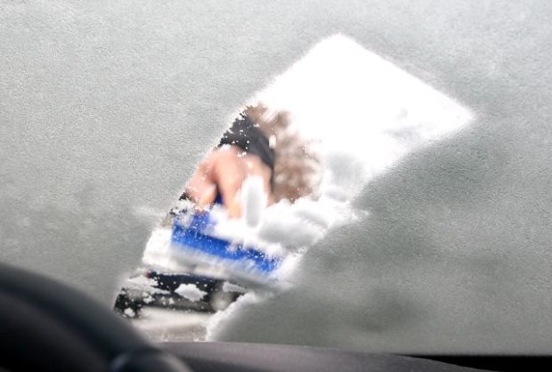 Detail Ansicht von innen das Auto der Frau Reinigung Auto fahrer Fenster  von Frost mit Hilfe spezialisierter Eis frost Schaber und gummigummiwalze  Autoscheibe im kalten Winter Stockfotografie - Alamy